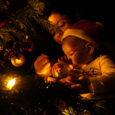 Baby an Weihnachten vor Weihnachtsbaum